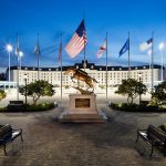 world equestrian center buillding with flags and horse statue in front