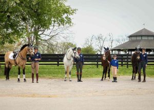 Four ponies standing with their riders