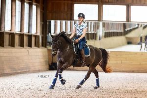 Horse and rider cantering in indoor