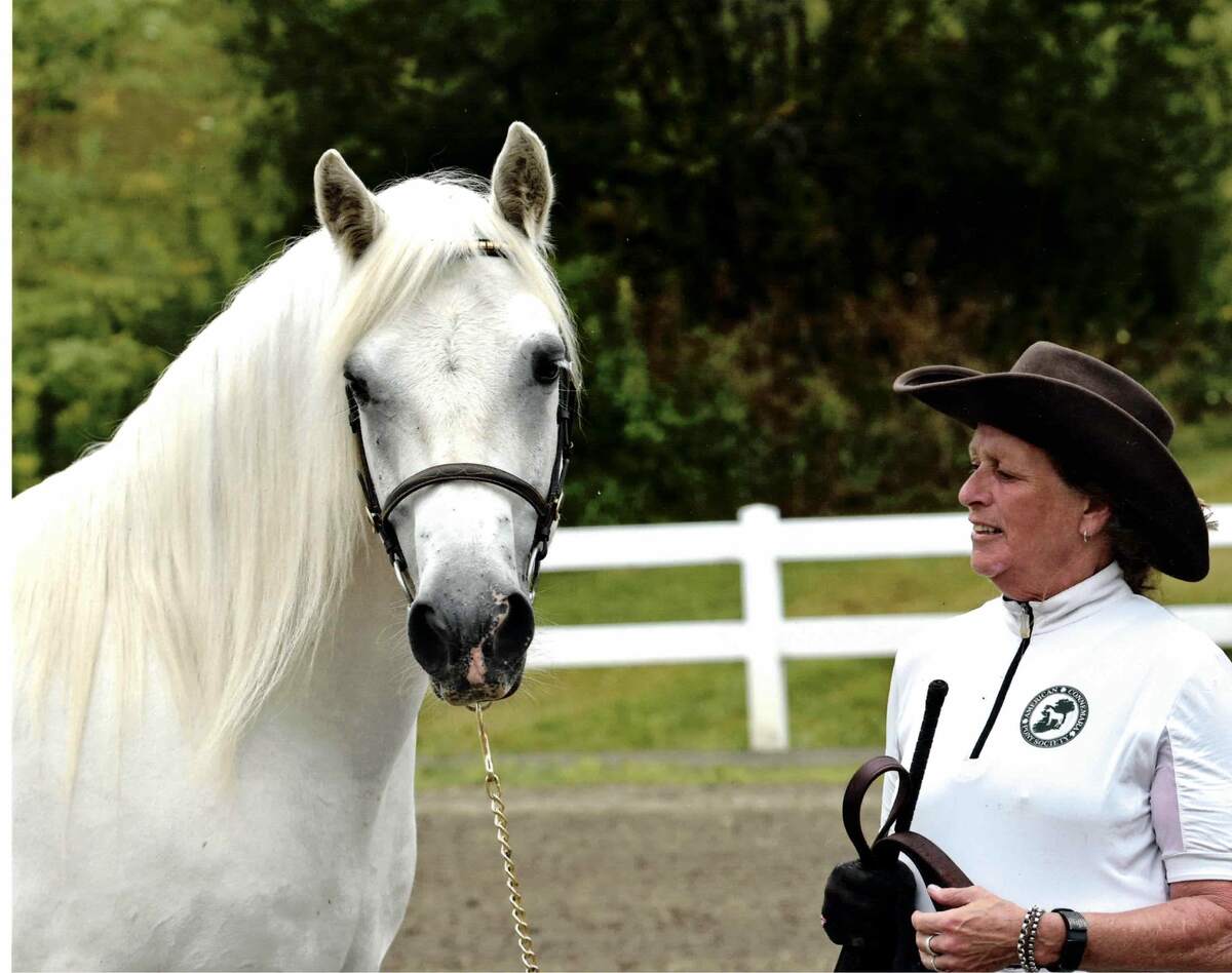 Woman standing next to pony